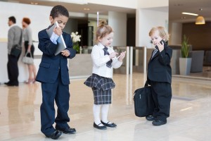Children with communication devices in business clothing